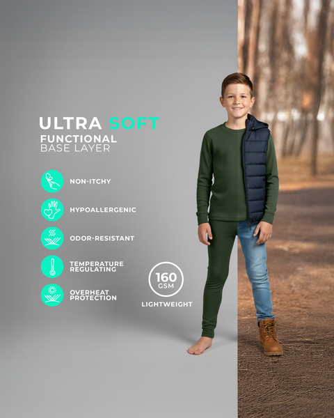 A boy wearing a dark green long-sleeve base layer top and matching leggings, standing barefoot against a split background showing both a studio setting and an outdoor fall scene. Icons on the left highlight features such as non-itchy, hypoallergenic, odor-resistant, temperature regulating, and lightweight 160 GSM fabric.