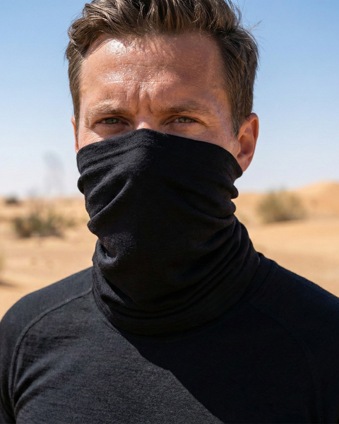 Man wearing black merino wool long neck gaiter outdoors, lightweight thermal face and neck cover for hiking and active use