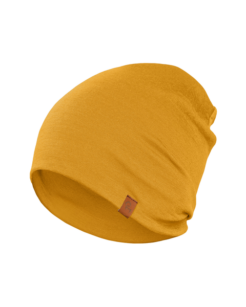 A close-up shot of a spicy yellow merino wool menique beanie hat is presented against a stark white background. The beanie has a slightly textured appearance and features a small, brown rectangular tag sewn onto its folded brim. The hat is softly draped and shows gentle wrinkles in the fabric.