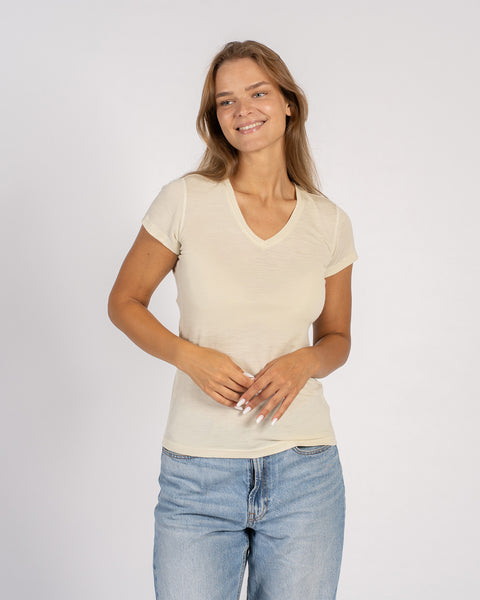 Woman wearing a natural-colored Merino wool V-neck T-shirt with short sleeves.