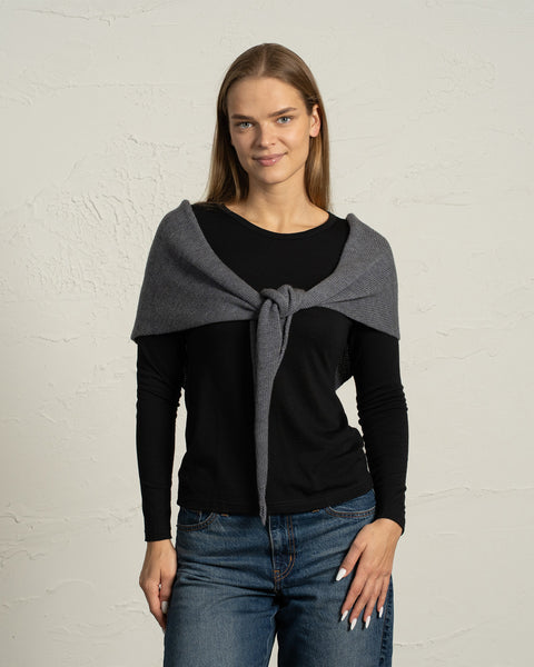 Dark gray merino wool bandana styled as a shoulder wrap on a woman.