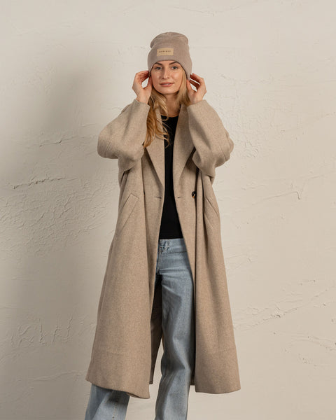 Woman wearing merino wool long sleeve top and knitted merino wool beanie with MENIQUE logo