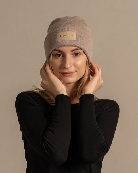 Woman wearing merino wool long sleeve top and knitted merino wool beanie with MENIQUE logo