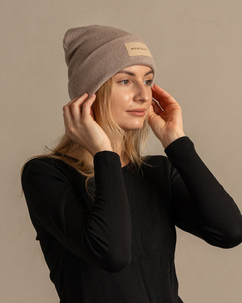 Woman wearing merino wool long sleeve top and knitted merino wool beanie with MENIQUE logo