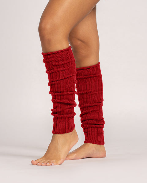 Red ribbed leg warmers worn by a person on a light gray background