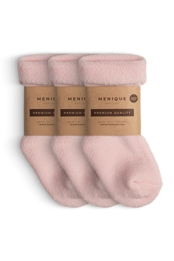 A 3-pack of kids’ pink sherpa-lined merino wool socks with Menique branding.