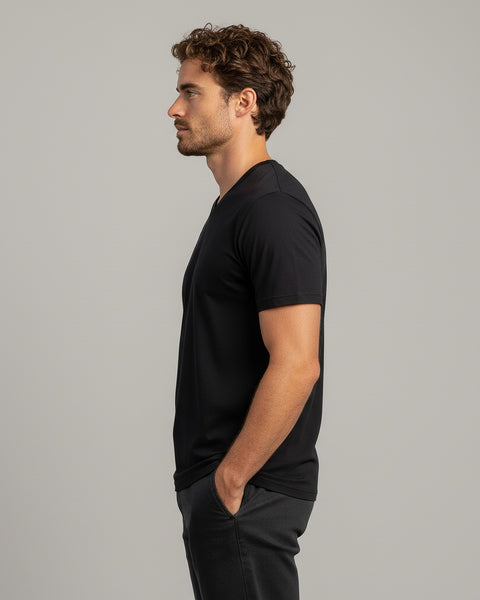 Man wearing a black t-shirt against a gray background