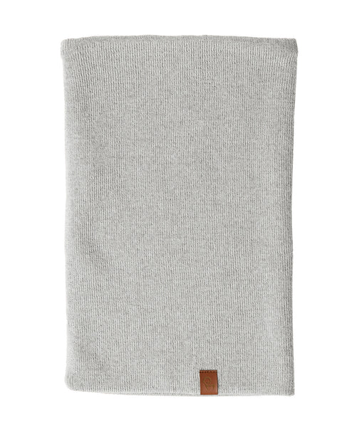 A light gray knit neck gaiter, likely made of merino wool, is displayed against a white background. The gaiter is shown laid flat and has a small brown tag at the bottom.