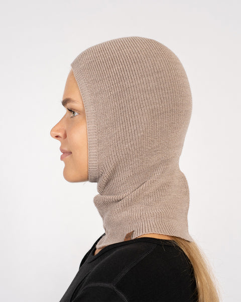 Side profile of woman wearing a creamy beige knitted Merino wool balaclava.