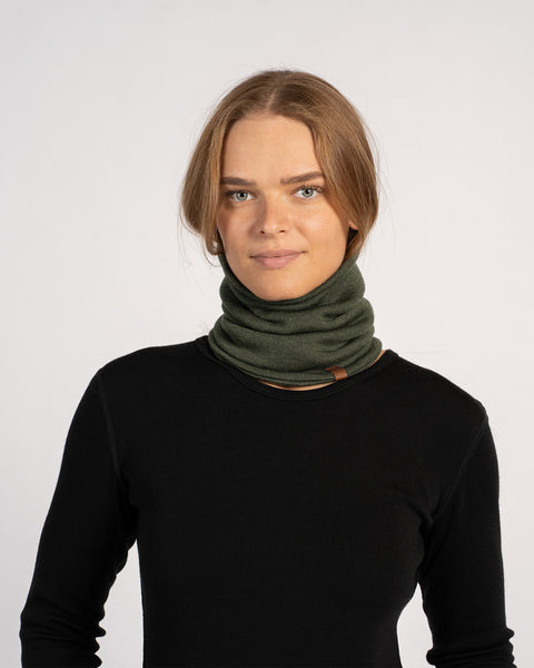 Unisex Merino Neck Gaiter in Dark Green, worn around the neck for warmth, styled with a black top.