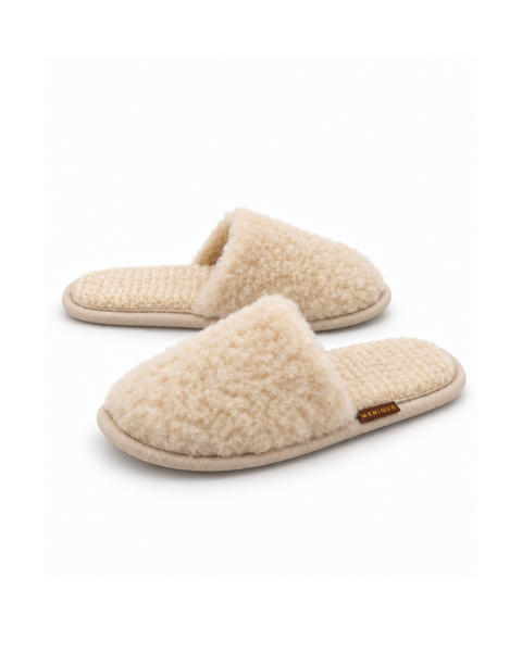 A pair of beige, fuzzy, slip-on style slippers with a matching textured footbed and a small brown "MENIQUE" tag.