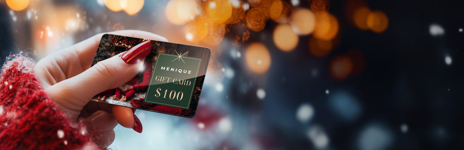 Hand holding a Menchie's gift card with a blurred festive background